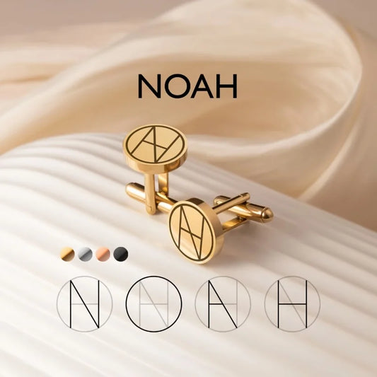 Gold cufflinks with a circular engraved 'NOAH' monogram, displayed on a cream-colored ribbed surface with draped beige fabric in the background. Four color options for the cufflinks are shown below.
