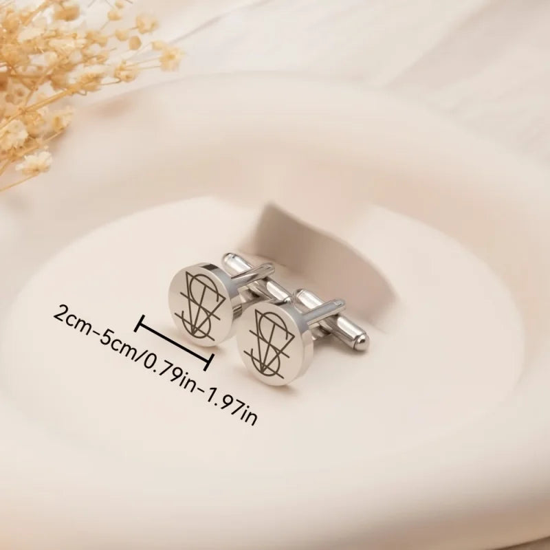 A pair of silver round cufflinks with engraved abstract line designs, displayed on a light cream plate with a dimension overlay indicating 2cm-5cm (0.79in-1.